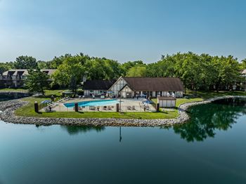 A backyard with a pool and a house next to a lake